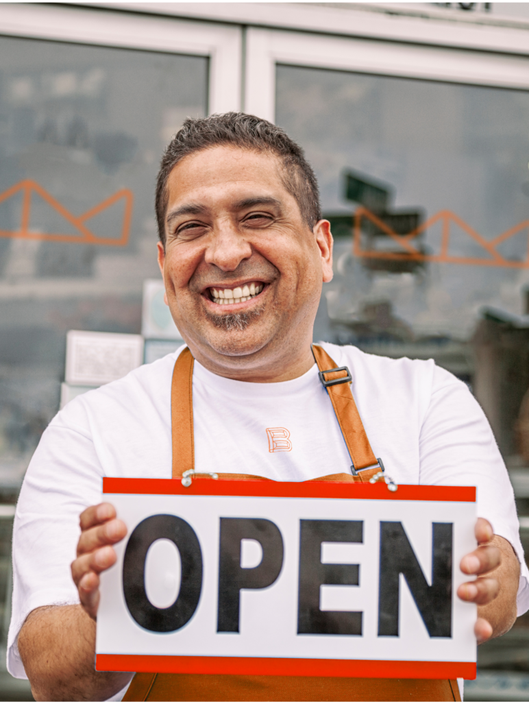 Franchisee holding an open sign